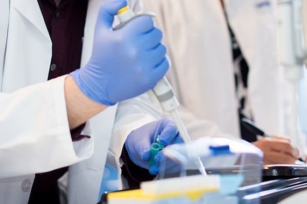 Researcher uses pipette in lab.